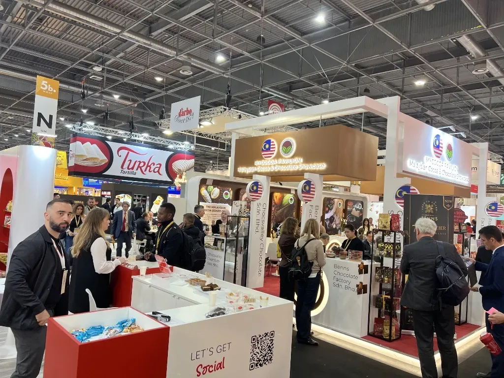 Produktauslagen und Besucher im malaysischen Kakao- und Schokoladenpavillon auf der SIAL Paris 2026.